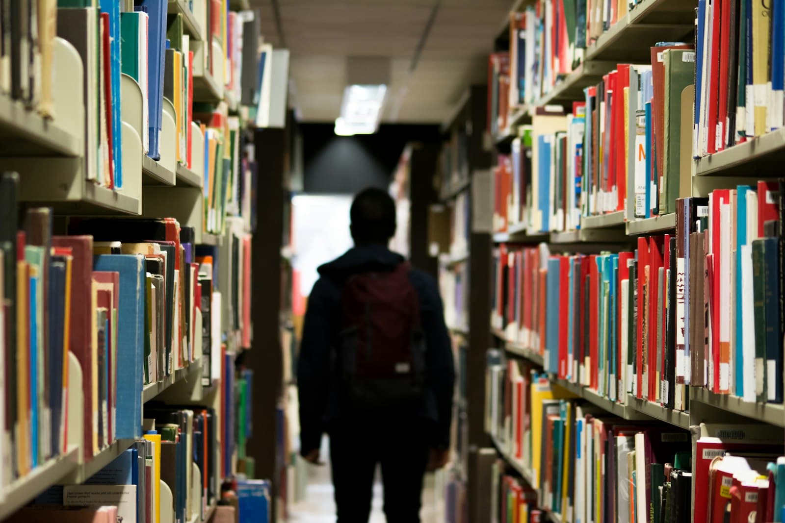 A person walking between library shelves